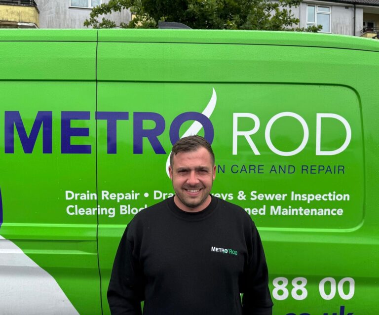 A picture of a Metro Rod drainage engineer, Harry Brewer, stoof in front of a Metro Rod drainage van