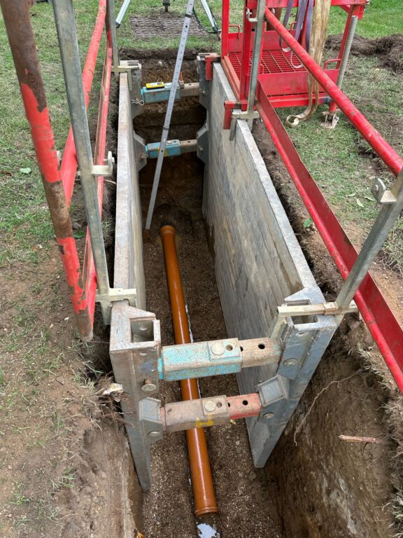 A picture of trench supports in an excavated trench to help stabilise the ground so Metro Rod engineers can safely repair the pipework